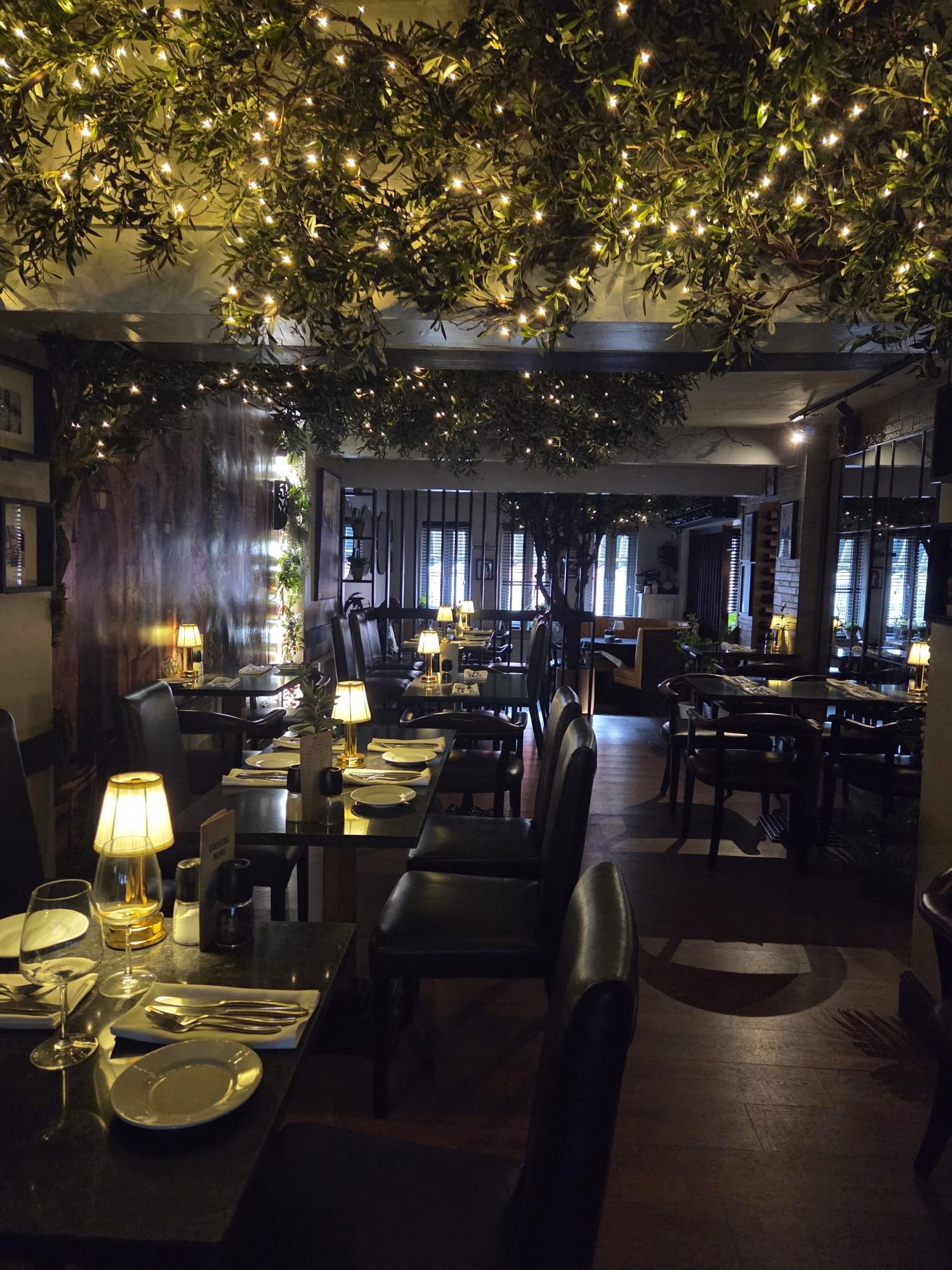 Bella Sera dining room with softly lit tables and leafy ceiling