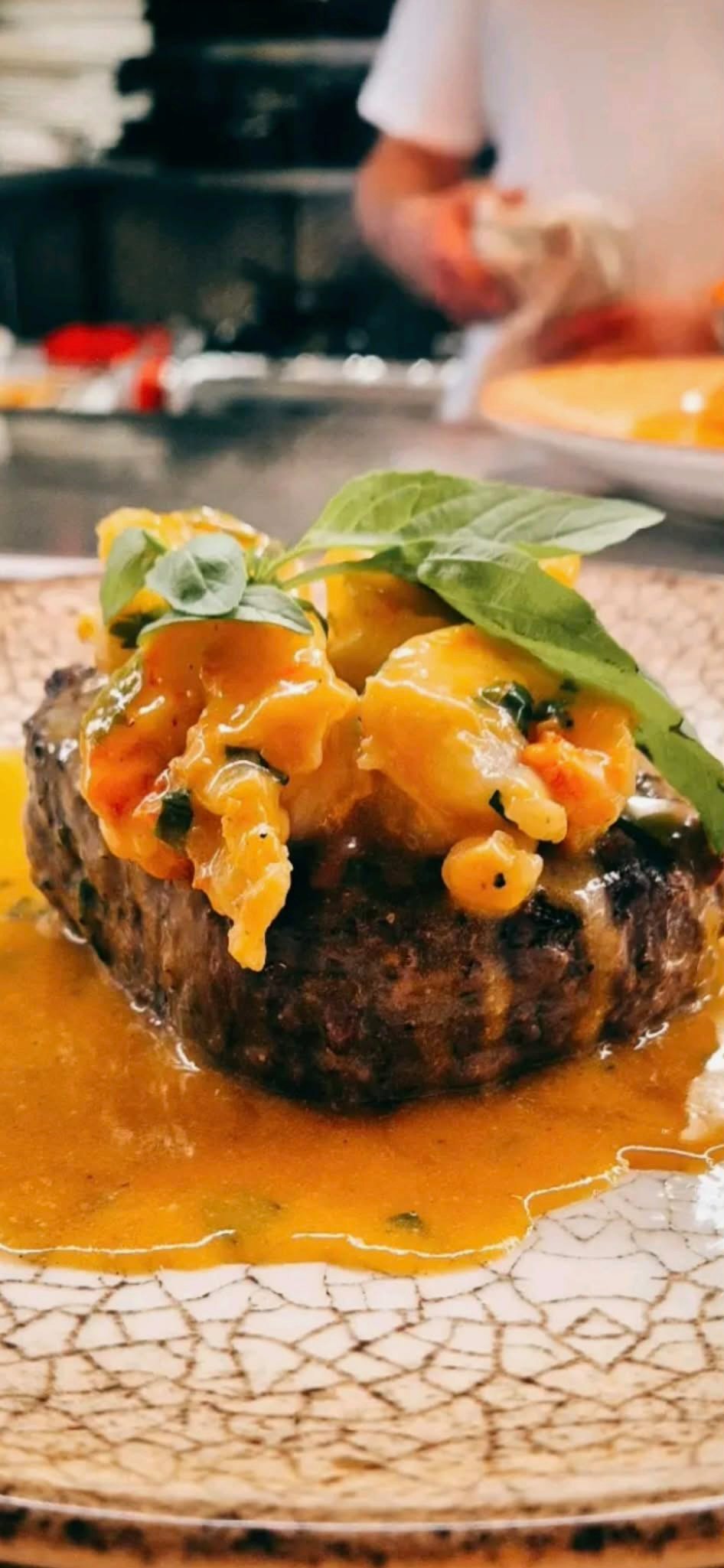 Steak topped with prawns and fresh herbs