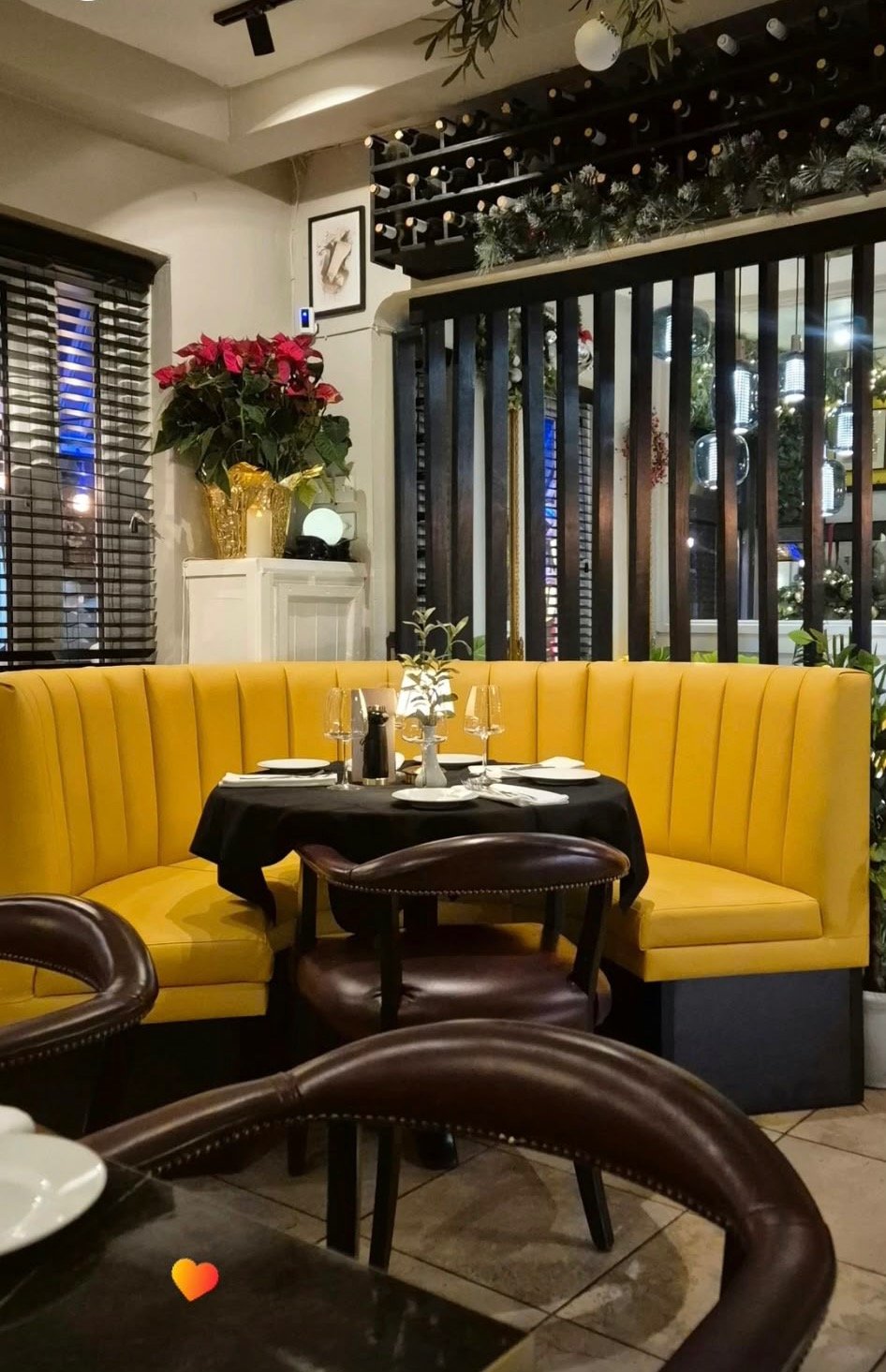 A table set beside Bella Sera’s yellow booth seating